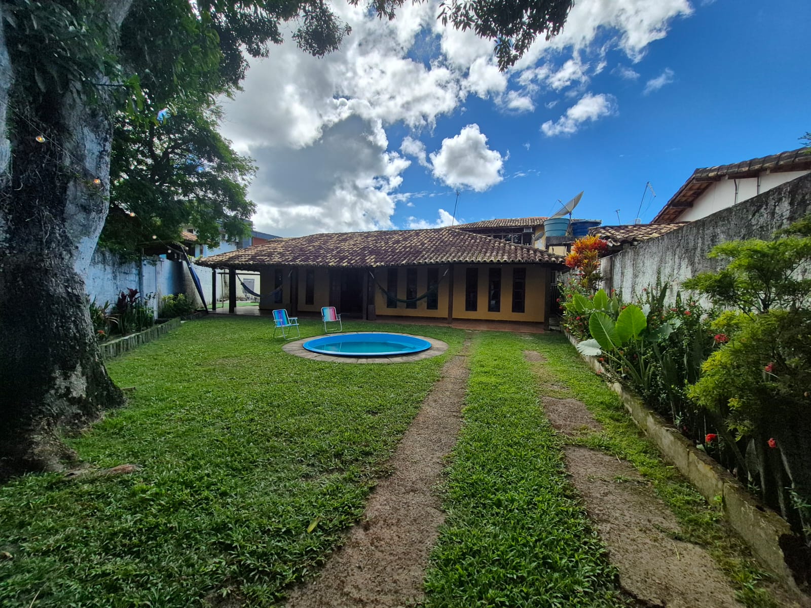 Fachada da casa com piscina e jardim